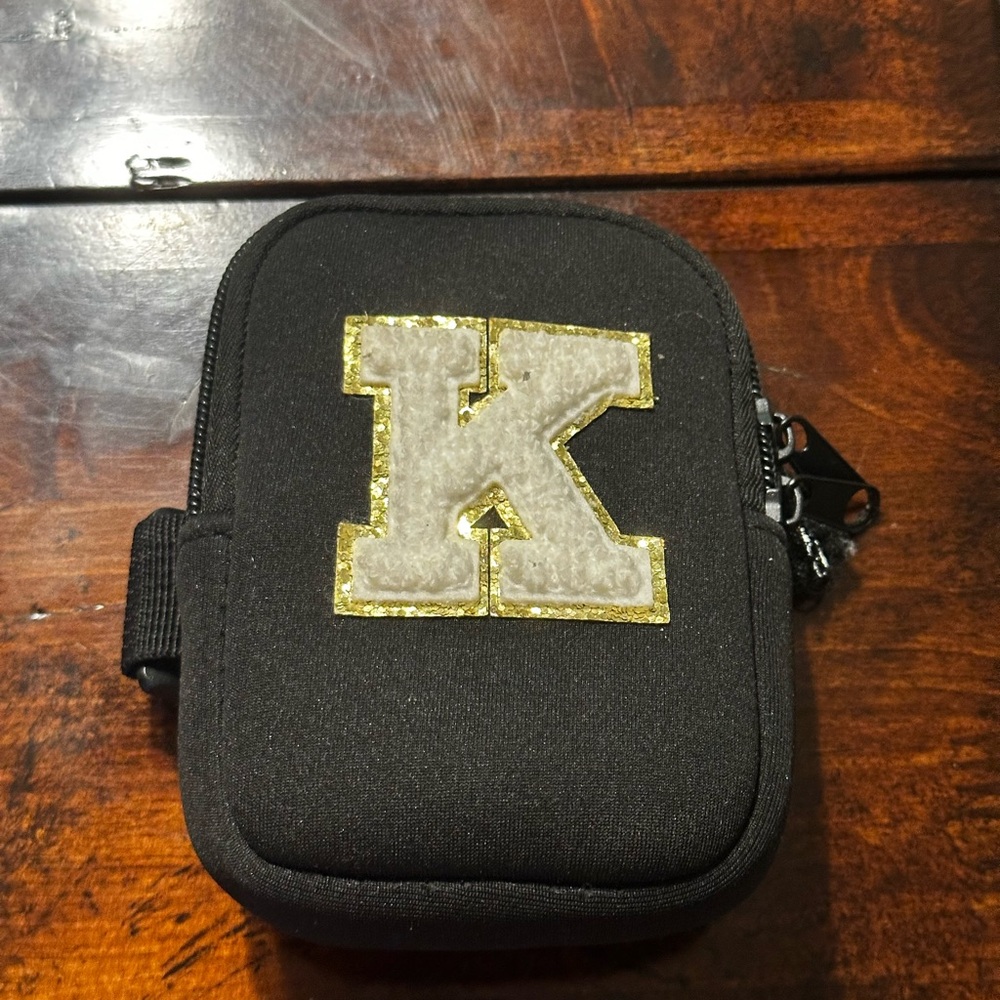 Black and Gold Zippered Bag with Decorative Emblem